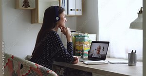 Girl sit in swivel chair at desk wears headphones greets 50s grandma enjoy distant talk using pc video conferencing app. On-line tutoring young student and mature teacher remote study activity concept