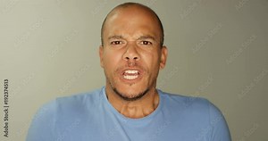 4K Close up portrait man staring into camera lens, shouting with mouth wide open. Slow motion.