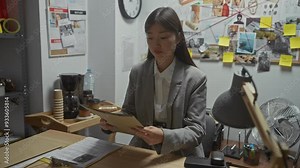 Asian woman detective stressed in office with investigation files and evidence board