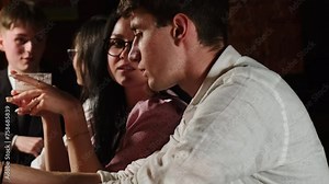 Young woman with cocktail flirts with man at night bar. Female thoughtfully listens to boyfriend enjoying beverage at bar counter Stock Video