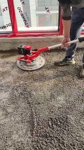 the process of compacting cement on the floor of a building or house using a special leveling tool.