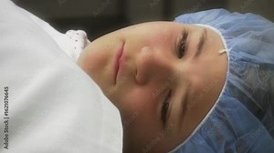 Zoom-In on Scared Young Girl Lying on Operating Table in Hospital
