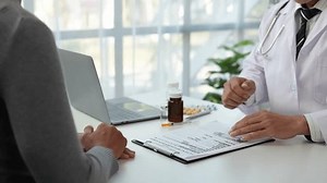 Asian male doctor or medical specialist examining a patient Ask for symptoms, give advice, recommend medication, plan treatment guidelines and preventive care. Concept of health checkup Prevention