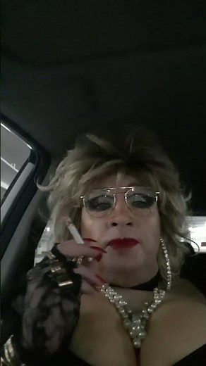 Crossdresser having a smoke in the car-park.