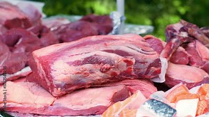 Raw beef lying on a pile of meat. Red meat for a BBQ. A lot of food prepared for an event. Animal protein for wealthy people. Fresh cuisine in Germany.