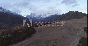 Aerial view of Autumn nature landscape of Mount Siguniang in Sichuan China with snow mountain peak in the clouds
