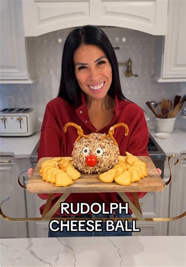 Rudolph Cheese Ball * 2-8oz blocks cream cheese * 1/2 cup tied cranberries, chopped * 1/4 cup parsley, chopped * 1/4 cup chives, chopped * 1 cup cheddar cheese, shredded * 1 tbsp ranch seasoning * 1 cup pecans, finely chopped * 2 edible eyes, 1 cherry tomato, 2 pretzels (to make the Rudolph face) * Crackers, to serve In a bowl, mix the cream cheese, cranberries, herbs, cheddar cheese and seasoning. Place this mixture in a plastic wrap and form the shape of a ball. Refrigerate for 15-20 minutes. 