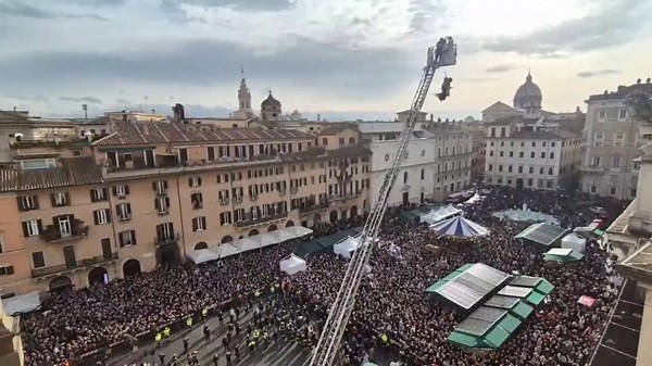 Witch on flying broomstick hoisted above Piazza Navona in Rome