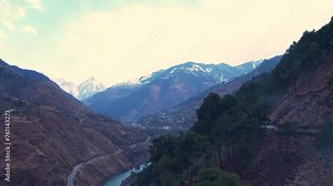 Valley landscape with a river, and snow-capped mountains in the background