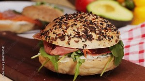 Bagel sandwich brunch, lunch plate of a bagel with smoked salmon and cream cheese and ham, close up morning cafe menu.