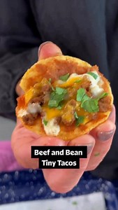 Tacos...but make them 🎀 cute 🎀 These Beef and Bean Tiny Tacos make the perfect party appetizer! Get the full recipe down below or at the link in the @allrecipes bio. 🌮 Ingredients: 1 pound ground beef 1 packet taco seasoning 1/2 cup water 48 round corn tortilla chips, from 1 (11 ounce) bag 1 (14 ounce) can refried beans 8 ounces shredded Mexican blend cheese 1/4 cup finely chopped cilantro 1/4 cup taco sauce for dipping, or as needed Directions: Preheat the oven to 350 degrees F (175 degrees