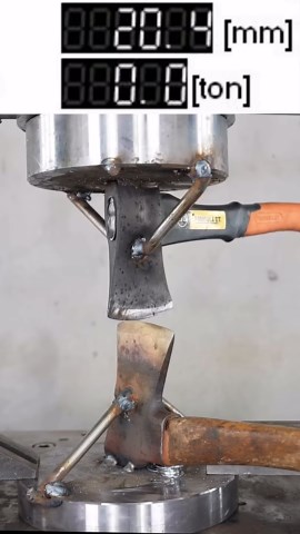 Hydraulic press testing a metal axe