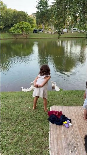 Girl mimics ducks by the lake in Bali, Indonesia