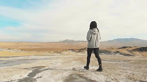 Young pretty caucasian woman walks on mud volcanoes. Travel destination in Georgia - Chachuna managed reserve