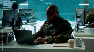 Intelligence agents in modern operations center managing surveillance activity and synchronizing security protocols. Army base staff interpret real time data to protect national interests. Camera A.