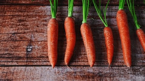 clip-3981378109-fresh-ripe-carrots-arranged-row-on-wooden