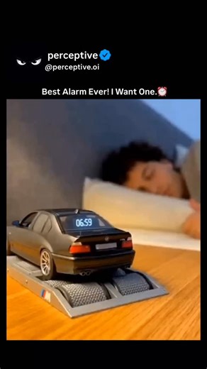 perceptive on Instagram: "This viral video features a concept of a BMW M5 (E39) Alarm Clock that simulates a high-performance engine “dyno” run to wake you up. As the clock strikes 7:00 AM, the miniature silver sedan—modeled after the legendary V8-powered M5—begins revving its engine, spinning its wheels on the rollers of a scale dynamometer, and even shooting blue flames from the exhaust. The audio is a dubbed recording of a real E39 M5 engine, creating the ultimate wake-up call for car enthusi