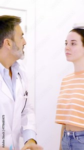 Doctor taking notes in a report while assisting a patient