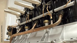 Panoramic view of parts of the vintage obsolete piston aircraft engine. Lots of pipes, crankshaft, connecting rod and other elements
