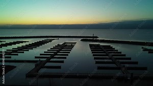 Flying over empty docks for boats on Lake Ontario at sunrise