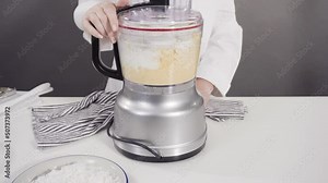 Mixing ingredients in a food processor to prepare homemade coconut cookies.