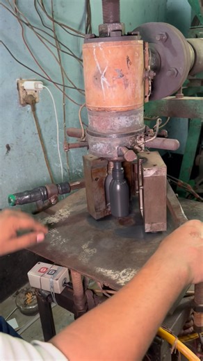 Making medicine bottles from plastic granules using an automatic machine.