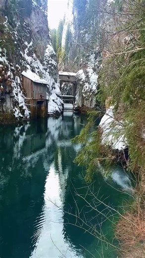 Romania on Instagram: "Does color have weight? At Scropoasa Lake in winter, the answer feels uncomfortably close to yes. The water settles into a deep, saturated green, not emerald, not jade, but something heavier and older, like oxidized copper left out in the cold too long. Snow clings to the Bucegi slopes above, firs stand silent, and the lake just stares back, unfrozen and unreadable, a slab of living color in a season that usually bleaches everything to bone. That green is not romance, it i