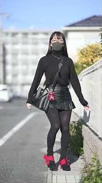 黒のフェイクレザーのプリーツミニスカートとブーツの組み合わせコーデです