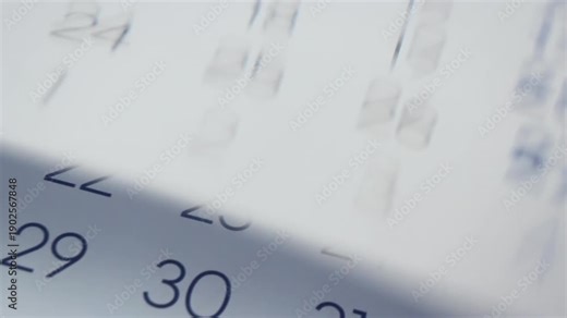 Time passing and inevitable changings concept. Close Up of paper calendar with pages turning quick