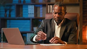 Focused executive businessman typing on laptop surfing social network on internet writing notes doing research busy man working online remotely at home office writes data from computer makes report Stock Video