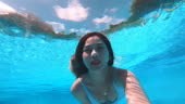 Asian women in diving underwater in pool and looking at camera