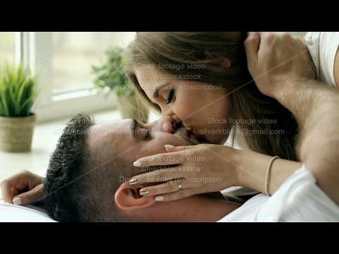 Closeup of Young beautiful and loving couple play and kiss in bed at the morning. Attractive man