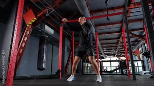 Male boxer teaches a fight with a shadow in dark sports club.