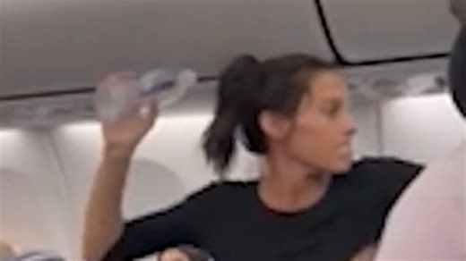 Furious woman throws bottle at passenger and rants at steward in flight altercation