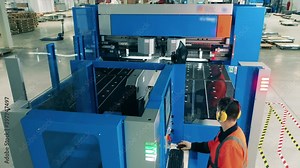 Male operator is working with a machine in the refrigeration factory facility.
