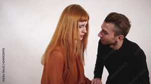 Young aggressive violent man grabs womans hands, squeeze her arms and woman try to protect heself and stop his violence.