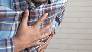 Download Young man suffering pain in heart and holding chest with hand for free