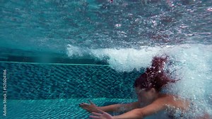 Underwater view of asian female swimmer. woman jumping into water pool . Swimmer jumping in big swimming. Ethnicity curly female floating blue water hotel pool. Asian student girl relax alone complex.