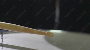 Super close up slow motion of a drum stick hitting a snare drum multiple times and bouncing off the snare. Shot in 4K.