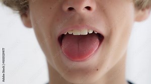 Child boy opens her mouth wide. child shows her teeth and mouth to dentist. mouth is wide open, tongue is stuck out as far as possible, with clear view of tongue and soft palate