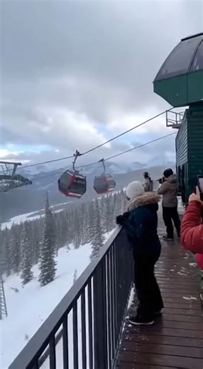 Gondola Cabin Detaches From Cable During Mountain Lift Incident Telluride, Colorado Video recorded at a mountain resort shows a dramatic moment when a gondola cabin appears to detach from its cable system high above a snow-covered slope. The scene unfolds against a backdrop of alpine peaks and dense evergreen forest as multiple cabins move steadily along the suspended line. As the lift continues operating, one cabin is seen misaligned from the cable before separating entirely. The detached gondo