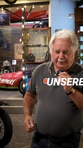 Die Gerd-Bender-Halle zählt zu den stimmungsvollsten Bereichen des BOXENSTOP Museums. 2000 erbaut, ehrt sie den deutschlandweit wie international erfolgreichen Rennfahrer Gerd Bender und bringt Motorsportgeschichte auf besondere Weise zum Leben. Zentraler Blickfang: die nachgebaute Boxengasse der Rennstrecke von Reims. Dazu wurde sogar echtes Kopfsteinpflaster verlegt – damit jedes Fahrzeug im authentischen Licht und in perfekter Szenerie wirkt. Ein Raum voller Geschichte, Charakter und echter R