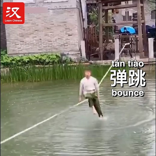 Perched over a river, this acrobat has turned tight-rope walking into tight-rope bouncing（弹跳 tántiào）! | Learn Chinese