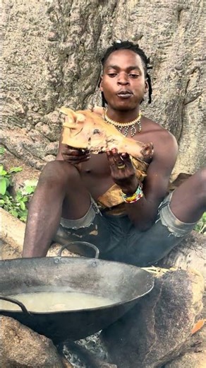 Hadzabe Man Enjoying Warthog Meat Under a Baobab Tree with Fellow Tribesmen 🌿🐗🔥