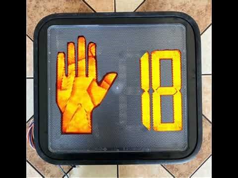 Newer Ge Ps7 crosswalk pedestrian signal with wall sign during the countdown