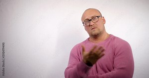furious bald man is shouting and gesticulating aggressive at camera, standing in white background