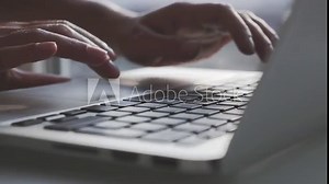 Close up fingers typing on laptop computer keyboard in office. Businessman or businesswoman hands typing on keyboard.