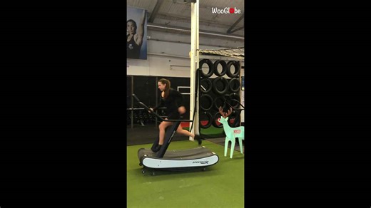 Woman runs full speed on treadmill wearing fine dress, heels