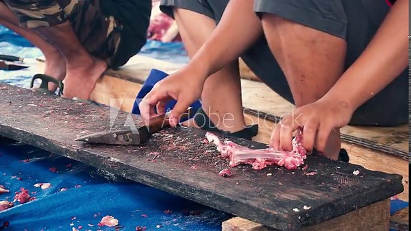 Eid al-Adha sacrifice by slaughtering cows and devotional work separating meat from ribs