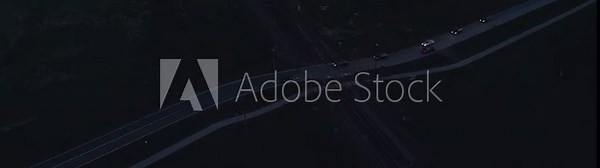 An aerial view of a night roadway scene showing sparse vehicle traffic, creating a serene nighttime drive experience